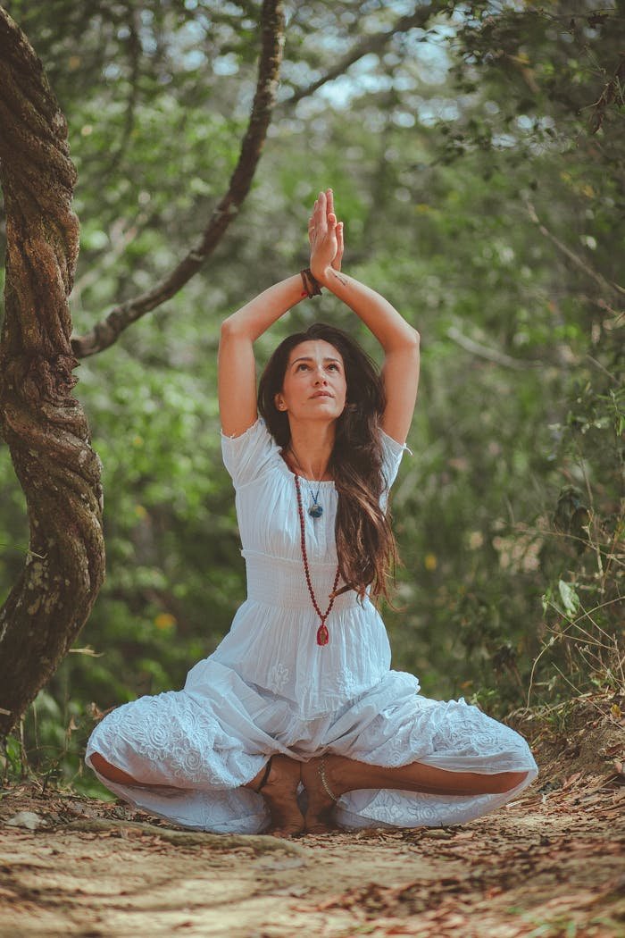 services-02 Woman meditating in a peaceful forest setting, embracing calmness and balance.