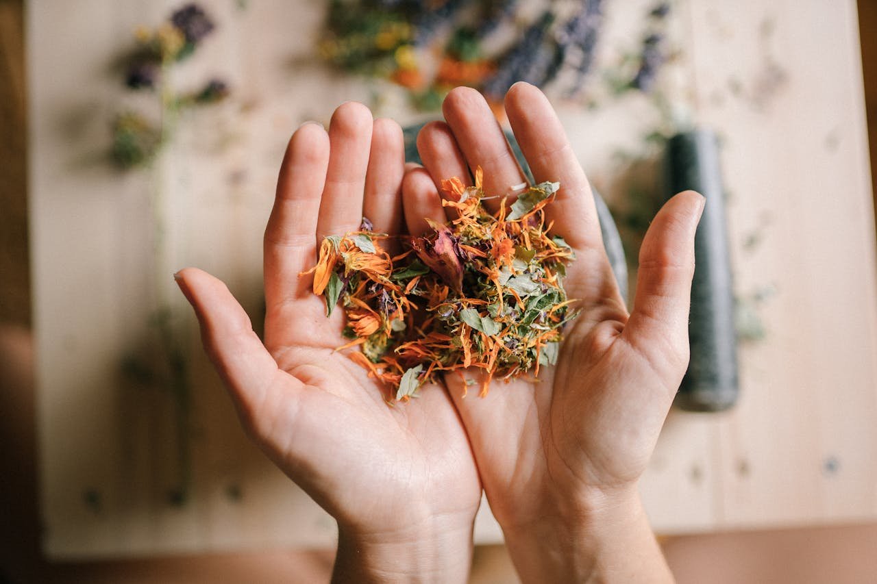why-choose-us Close-up of hands holding a mix of vibrant dried herbs on a wooden surface.
